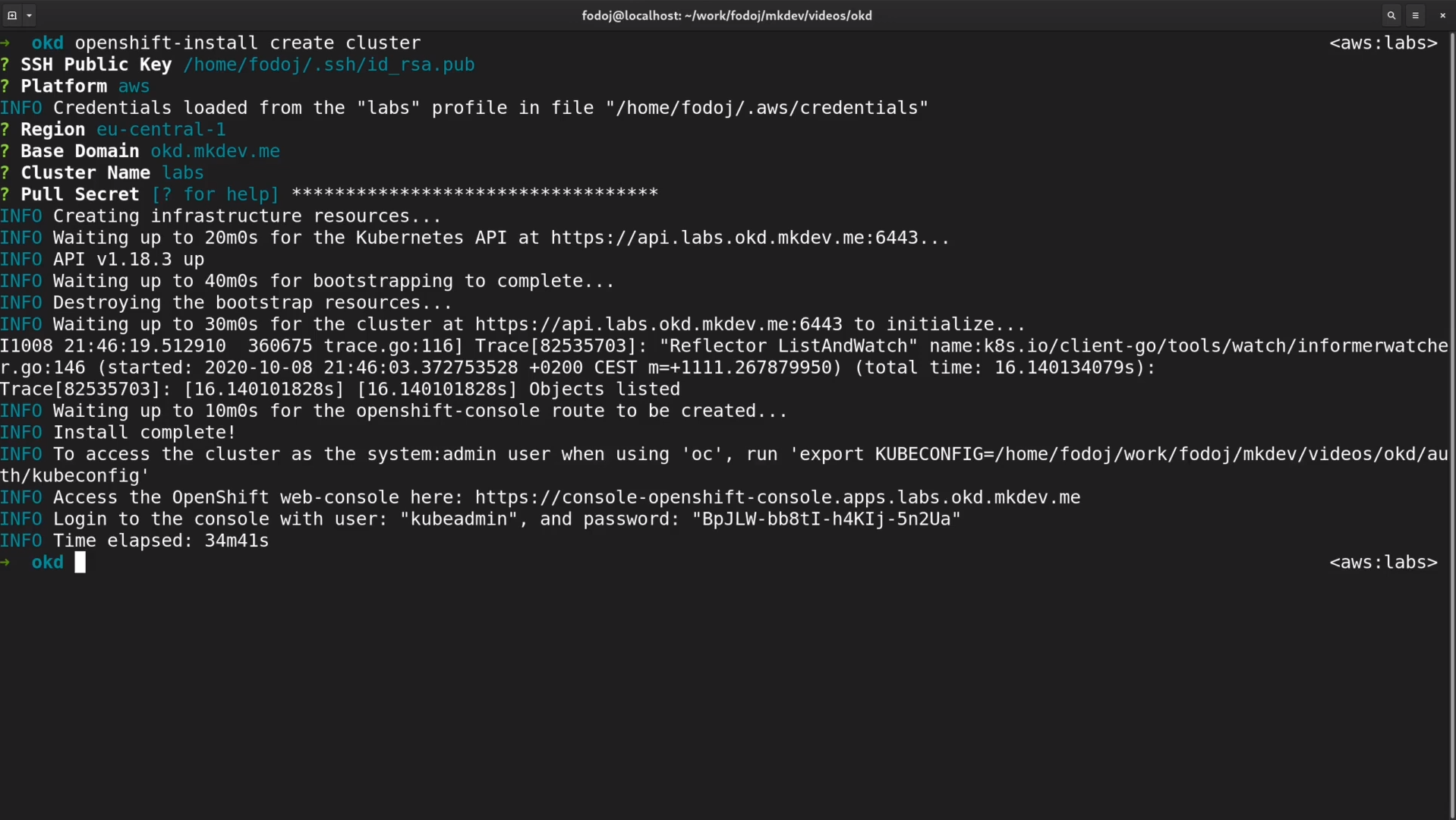 Command line interface showing successful installation of an OpenShift cluster with details including SSH public key, AWS region, domain, and access information for the OpenShift web console.