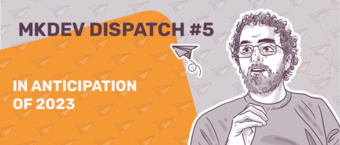 Promotional banner with a stylized illustration of a bearded man for MKDEV Dispatch #5 featuring text "In anticipation of 2023" against an orange background with paper airplanes.