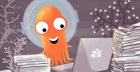 An illustration of a cheerful orange octopus wearing a space helmet, sitting at a desk using a laptop, with stacks of paper on both sides, and coral branches in the background.